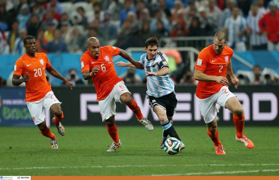 Lionel Messi inseguito da ben tre avversari. Action Images